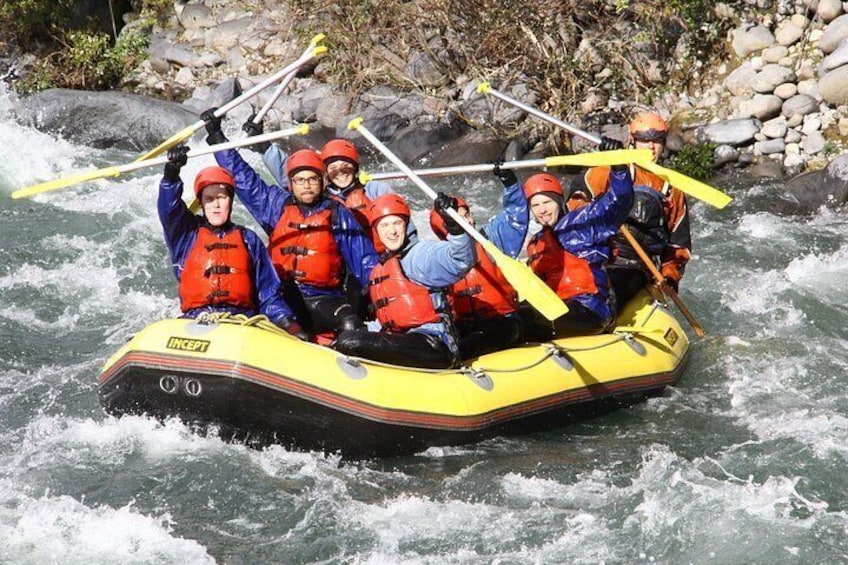 A group of people in a yellow inflatable raft on a river. 2