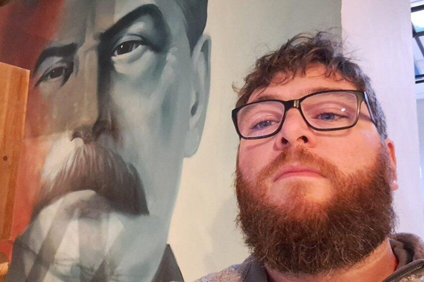 En person står foran en stor muralmaleri. 2