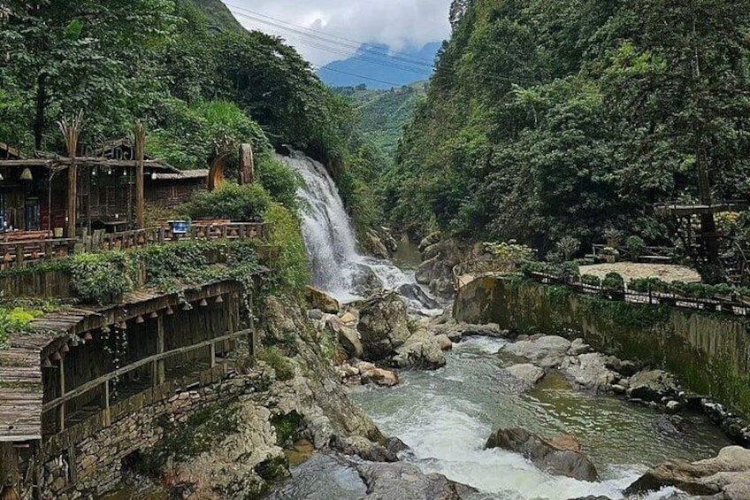 A waterfall, a wooden bridge, and a river in a forested valley. 5