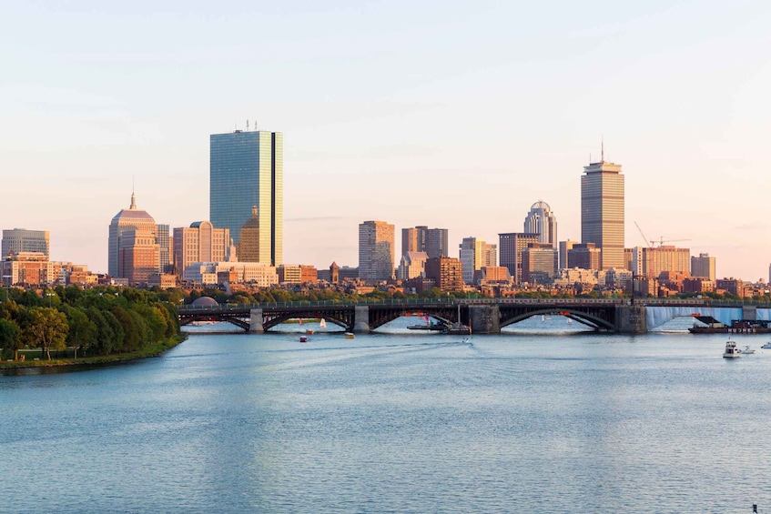 A city skyline with modern skyscrapers, a river with boats, and a bridge connecting two parts of the city. 3
