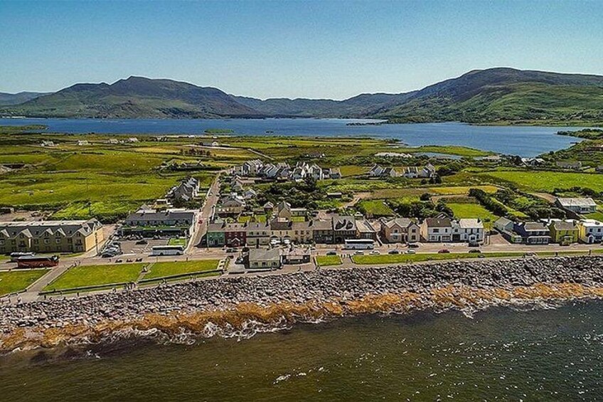 A coastal town with houses, a rocky shoreline, and a body of water in the background. 2