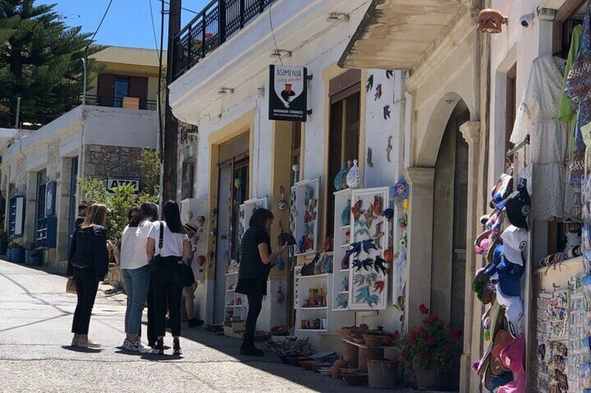 A street with shops and people standing outside. 2