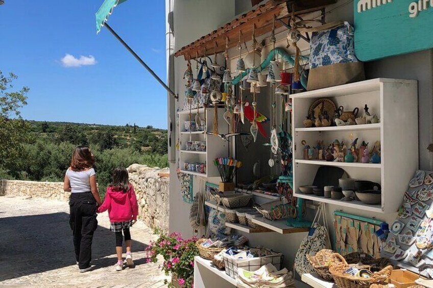 A woman and a child standing in front of a shop with ceramic items on display. 5
