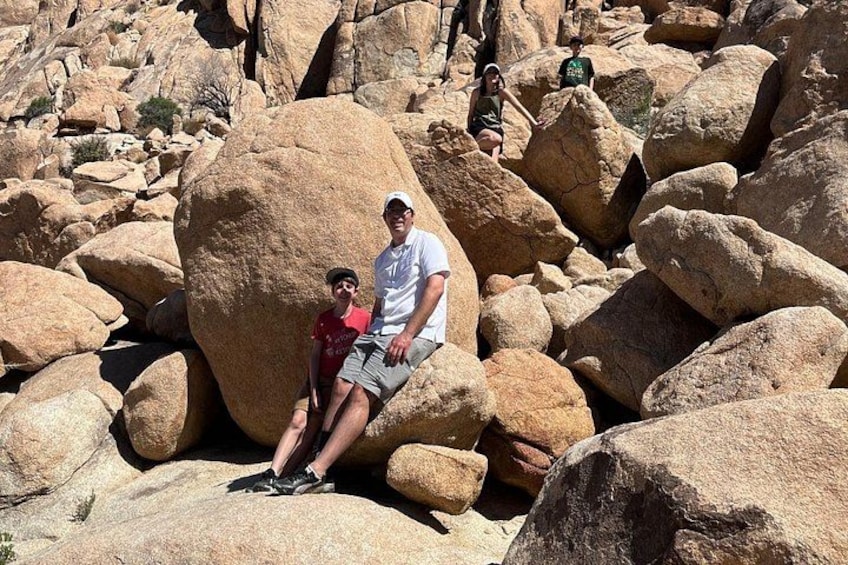 Two people sitting on large rocks in a rocky landscape. 5