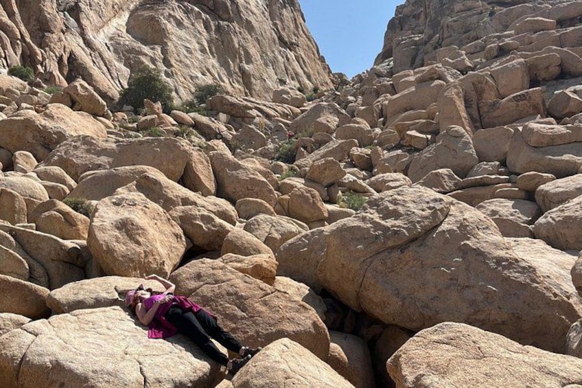 A person lying on a rocky surface in a mountainous area. 3