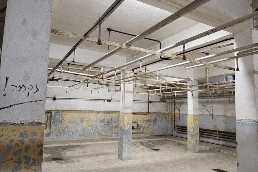 Een verlaten gebouw met blootliggende leidingen, betonnen pilaren en graffiti. 3