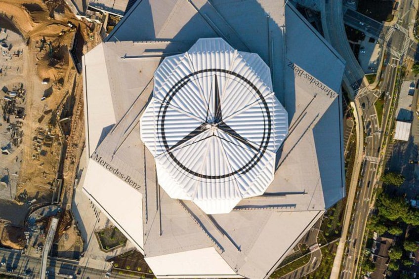 A large, modern building with a distinctive circular design and the Mercedes-Benz logo. 1