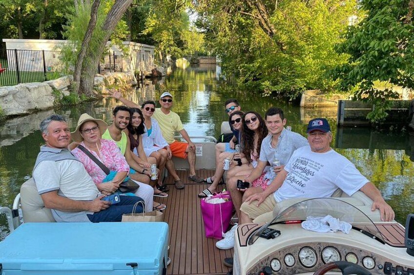 A group of people on a boat in a canal surrounded by greenery. 3