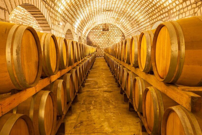 A wine cellar with rows of wooden barrels. 3