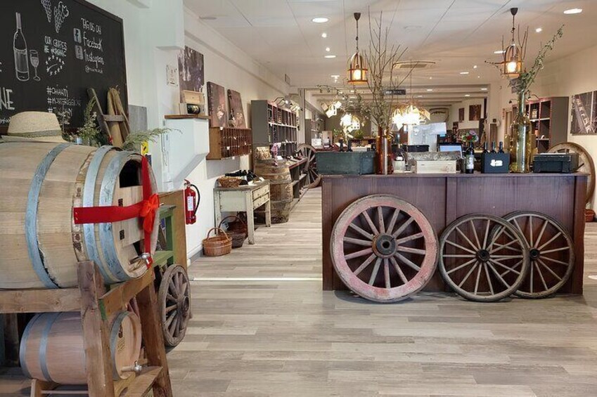 A store interior with wooden barrels, a counter with wheels, and shelves with various items. 5