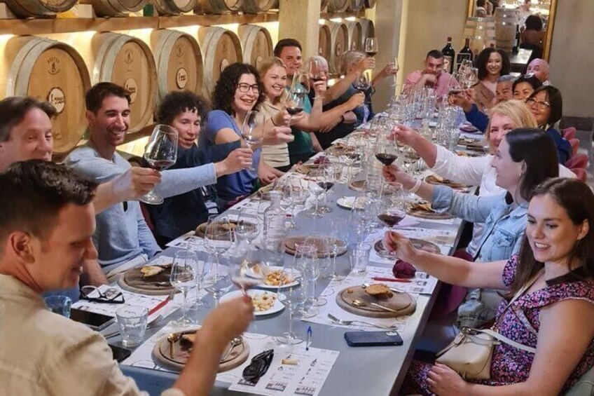 A group of people toasting at a long table with wine glasses. 3