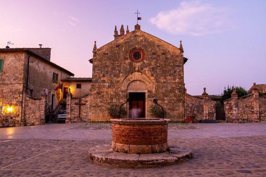 A historic stone church with a central fountain, surrounded by cobblestone streets and traditional buildings. 3