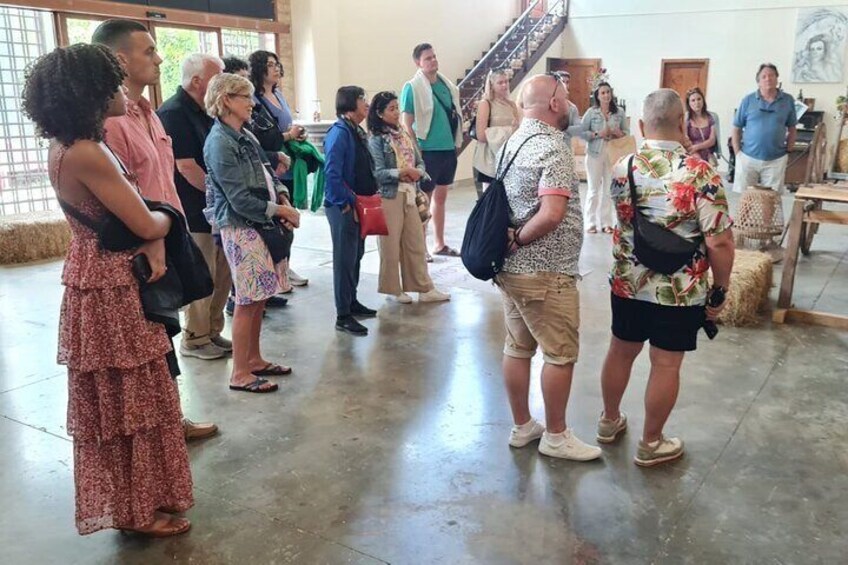 A group of people standing in a spacious indoor area with a staircase in the background. 4