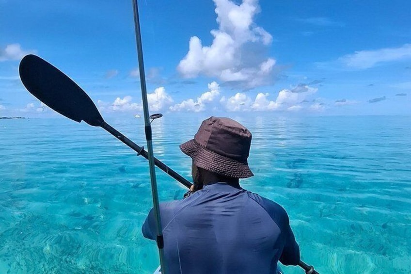 Una persona remando un kayak en aguas turquesas y cristalinas. 5