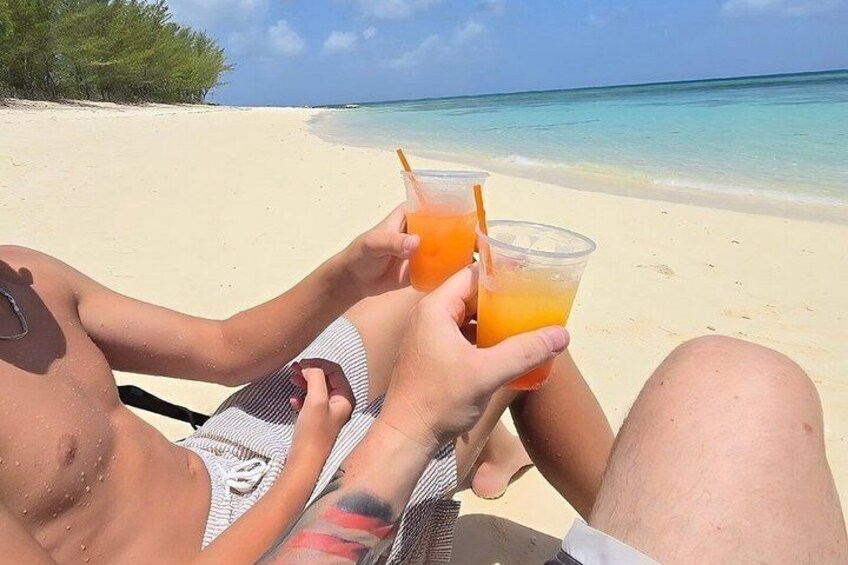 Dos personas descansando en la playa con bebidas. 4