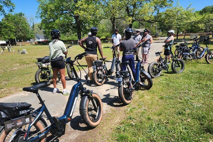 A group of people with bicycles in a park. 5