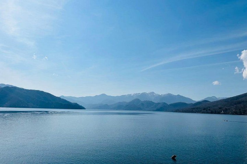 Un lago tranquillo circondato da montagne sotto un cielo sereno. 5
