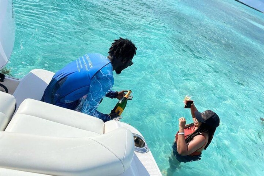 Une personne vêtue d’une combinaison de plongée bleue se trouve sur un bateau, une autre personne porte un maillot de bain noir, et l’eau est d’un bleu limpide. 4