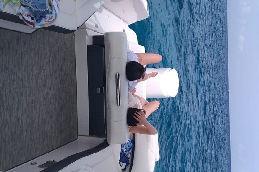 Un bateau sur lequel une personne est assise au bord, contemplant la mer. 5