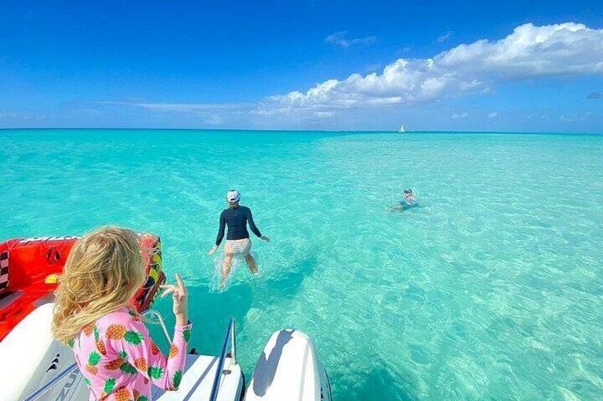 Un bateau avec deux personnes qui nagent dans une eau turquoise et cristalline. 1