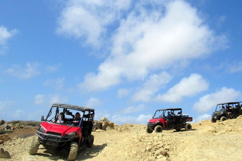 Off-road vehicles on a sandy terrain under a clear sky. 3