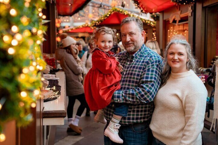 A family at a festive market with Christmas decorations. 5