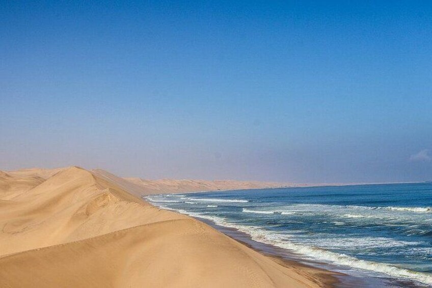 A desert landscape with sand dunes and a coastline. 3