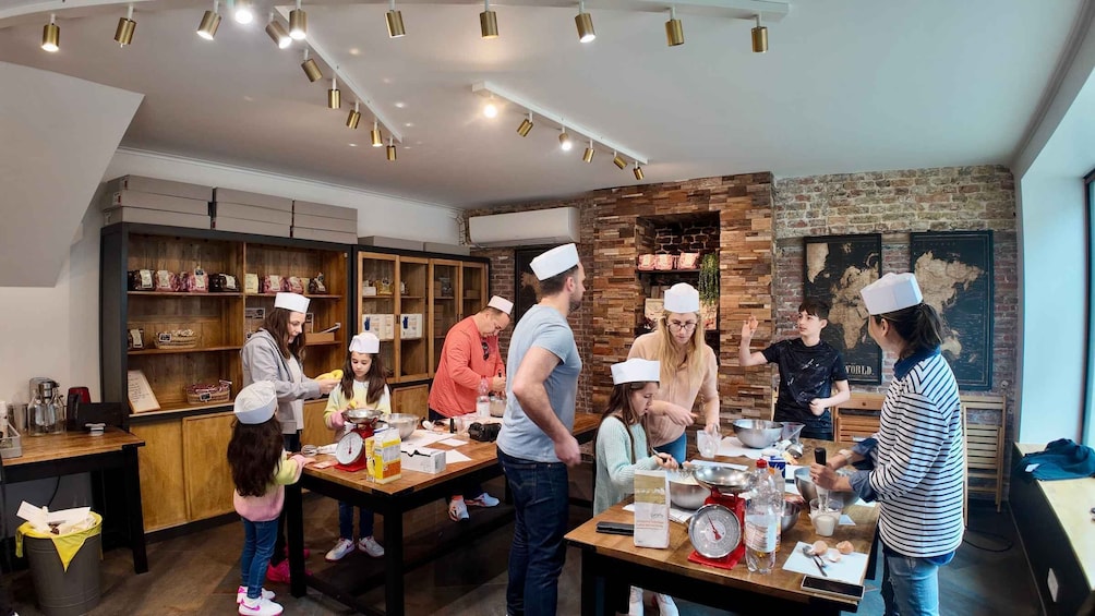 Un grupo de personas en una cocina, algunas con gorros de chef, preparando comida. 1