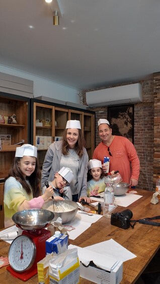 Una familia cocinando junta en una cocina con estantes de madera y una pared de ladrillo. 5