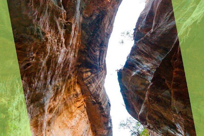 Een canyon met gelaagde rotsformaties en een smalle doorgang. 4