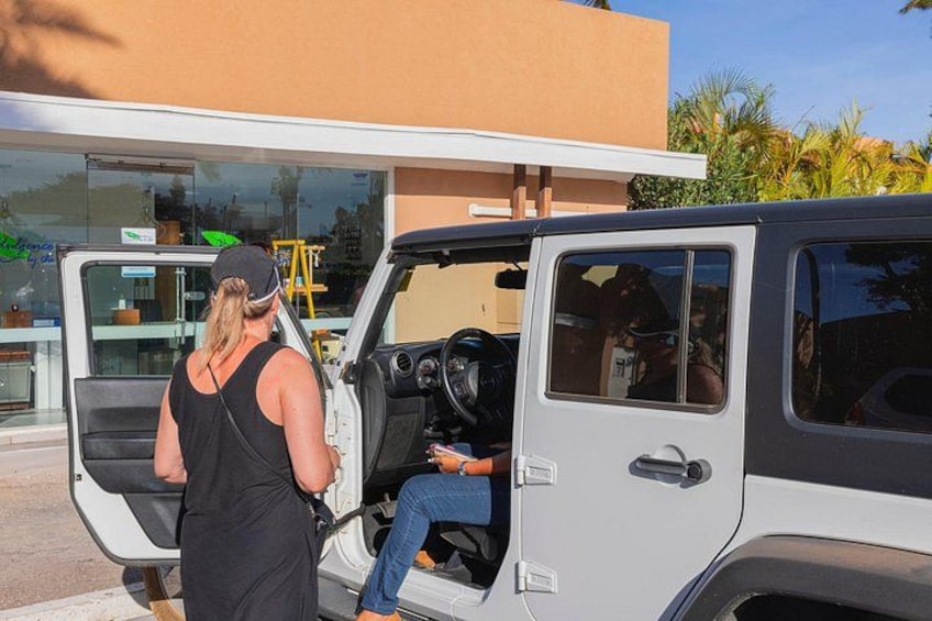 A white SUV parked in front of a building with open doors. 3