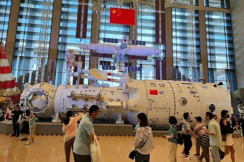 Un transbordador espacial grande exhibido en un museo, con visitantes a su alrededor. 3