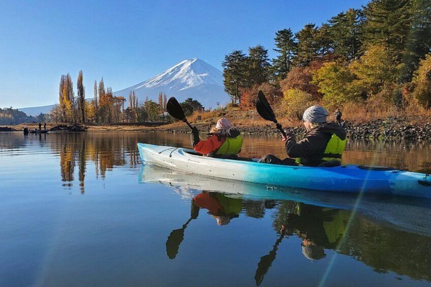 Two people kayaking on a calm lake with a mountain in the background. 4