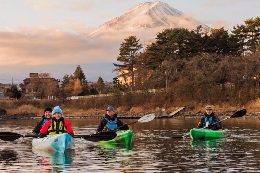 Tres kayakistas en un río tranquilo, con una montaña al fondo. 4