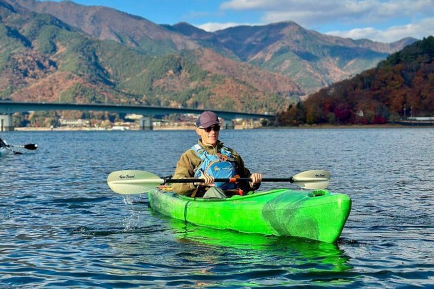 Una persona haciendo kayak en un lago con montañas al fondo. 5