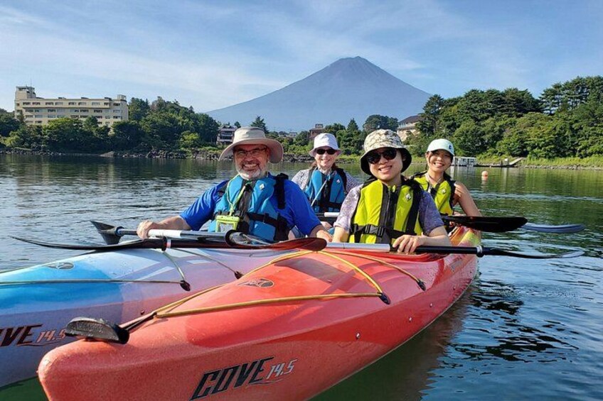 A group of people kayaking on a calm river with a mountain in the background. 3
