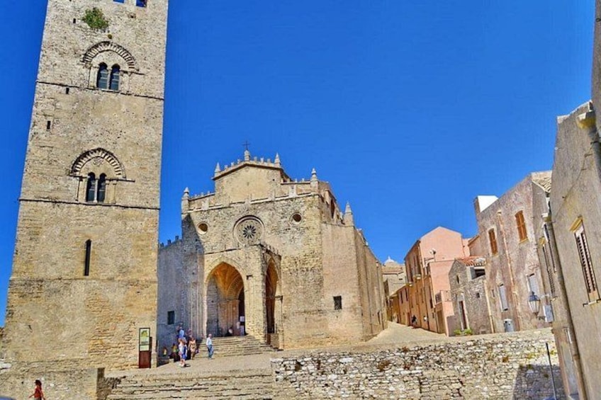 A historic stone building with a large arched entrance and a tall tower. 4