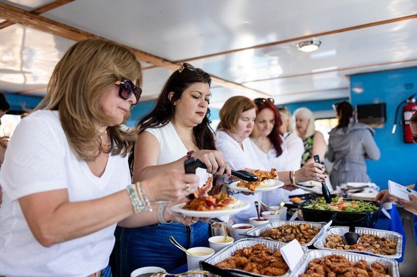 Personas comiendo en un bufé con diversos platos y bebidas. 2