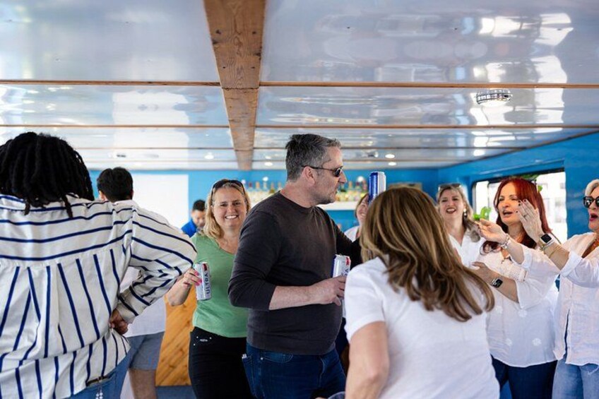 Personas bailando en un espacio cubierto con vigas de madera y una pared azul. 4