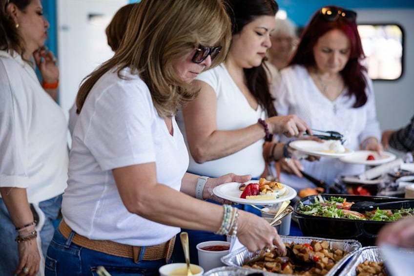 Personas sirviendo comida en un evento al aire libre. 1