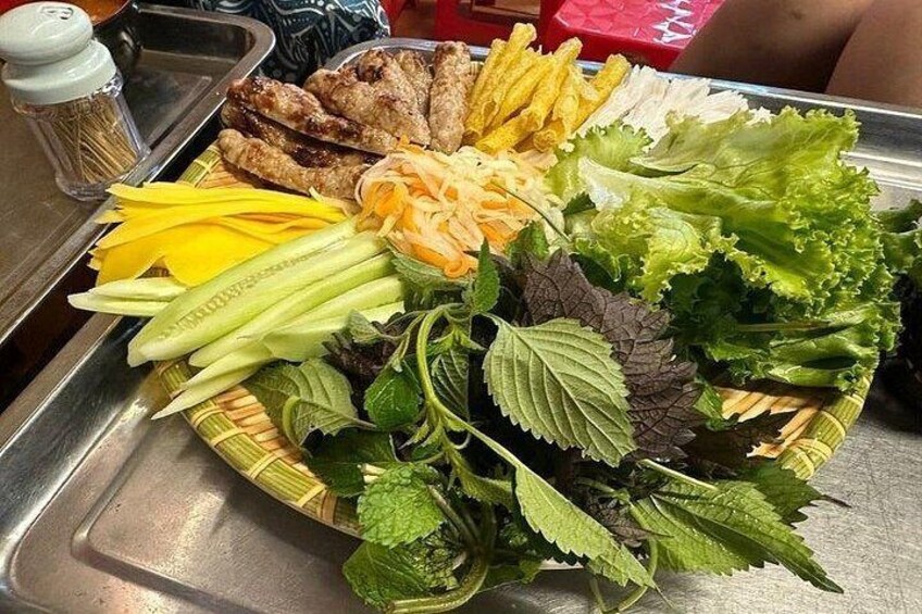 A plate of food with grilled chicken, fried items, and various fresh vegetables. 2