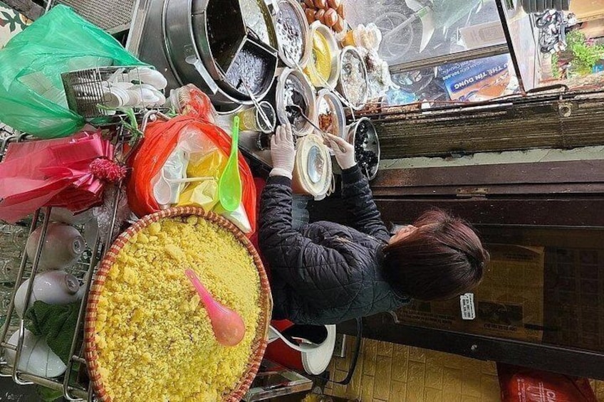 A person arranging dishes on a table with various food items and containers. 4