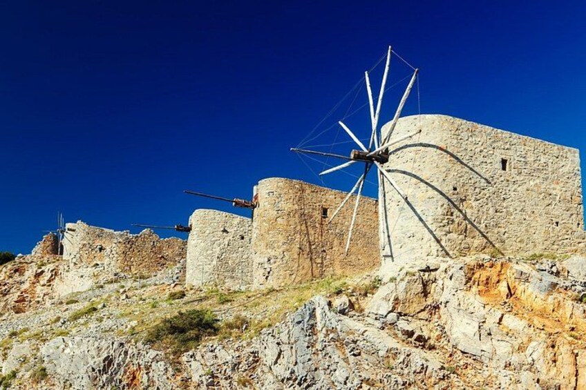 A windmill, stone walls, and a clear blue sky. 4