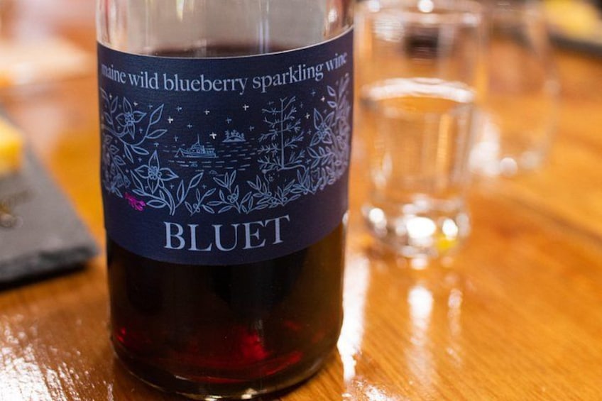 A bottle of Bluet wine with a label that reads 'Maine wild blueberry sparkling wine.' 2