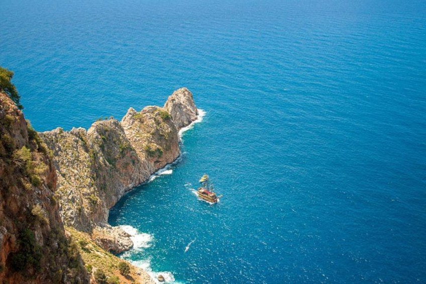 A coastal cliff with a boat in the water. 3