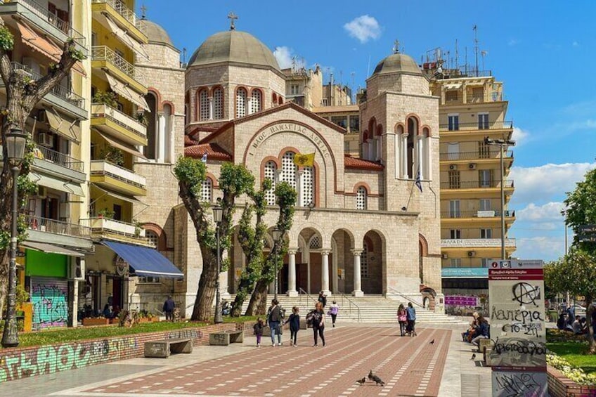 A historic building with domed architecture, surrounded by modern buildings and a pedestrian area. 5