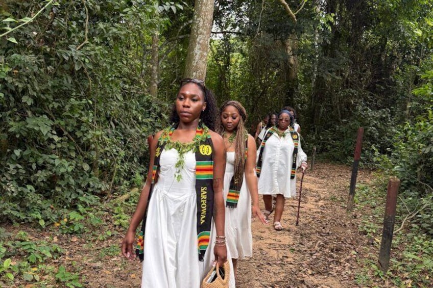 Un grupo de personas vestidas con atuendos tradicionales caminando por un bosque. 5