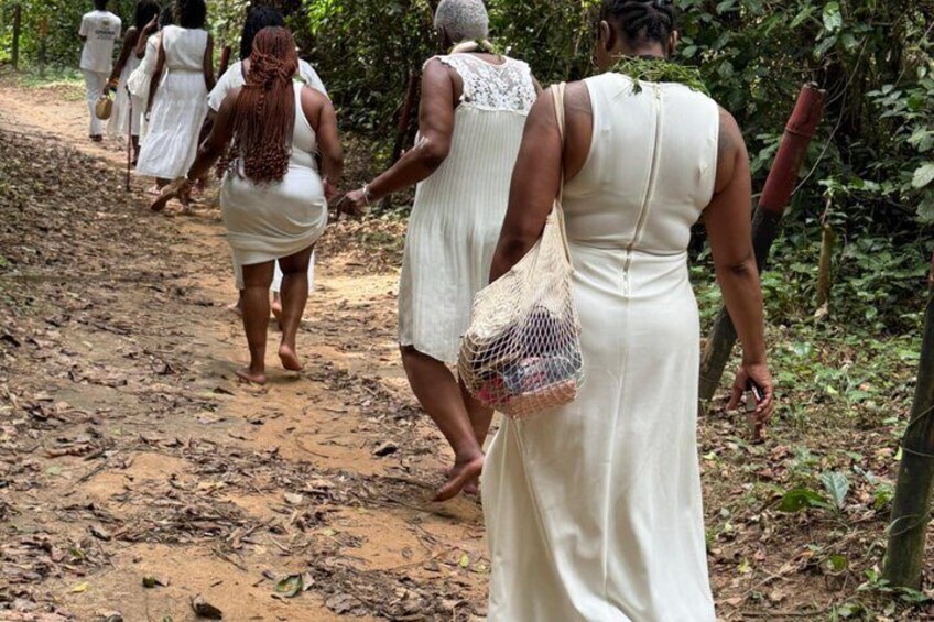 Un grupo de personas caminando por un sendero de tierra en un área boscosa. 3