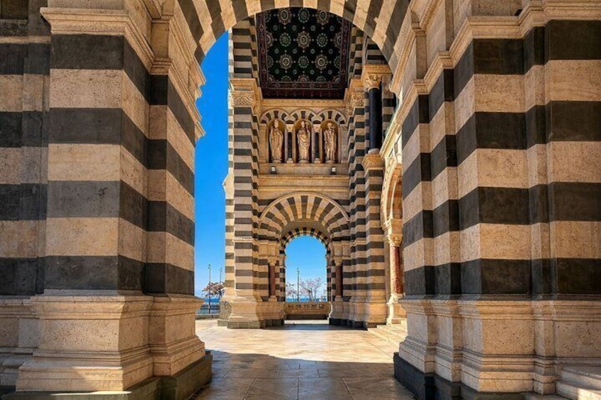 An arched doorway with striped columns and a patterned ceiling. 4