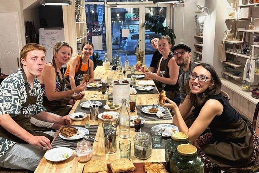 Un grupo de personas sentadas alrededor de una mesa con comida y bebidas. 3